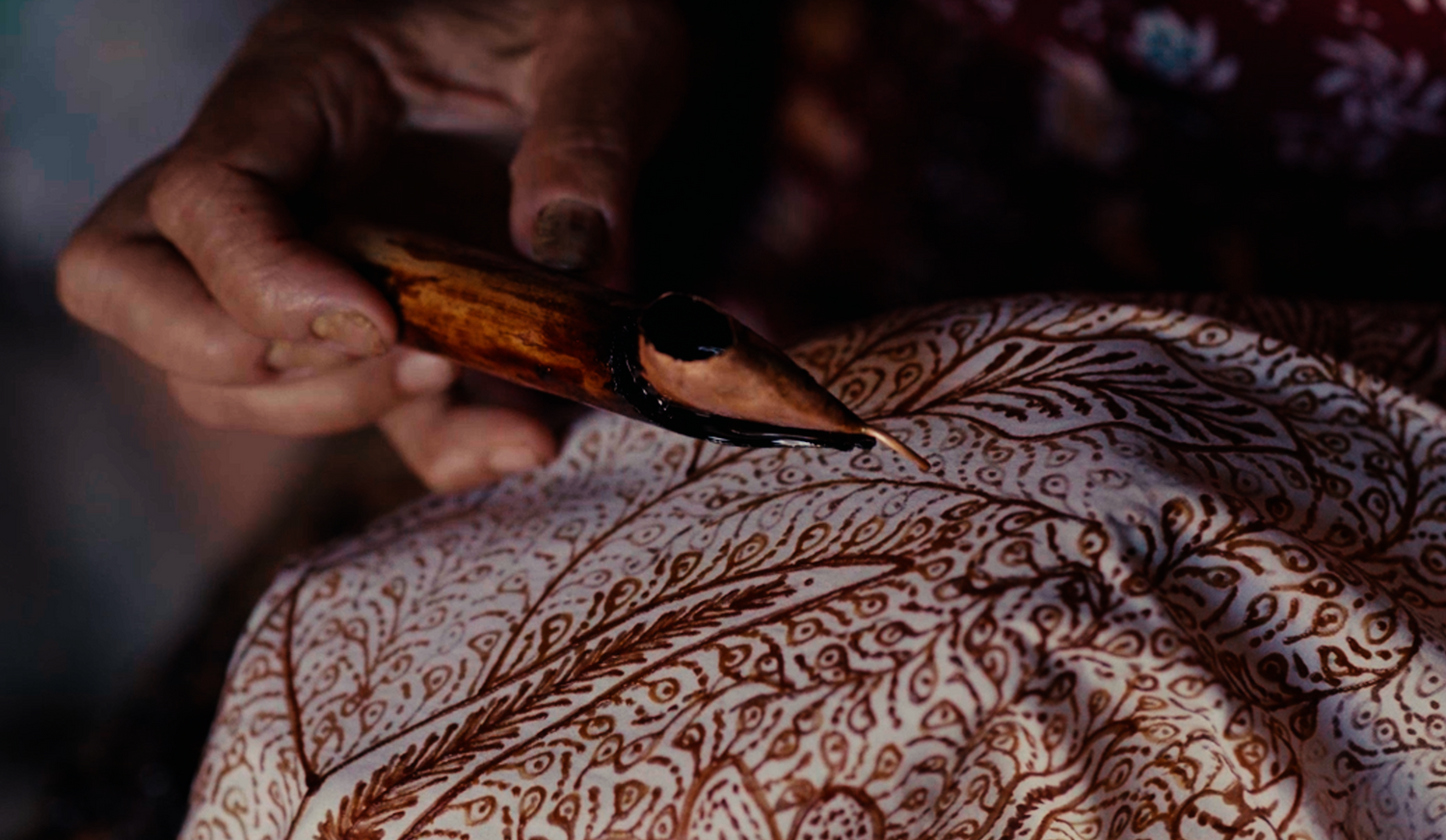 Close up of Ibu Nandiroh creating batik tulis with a canting